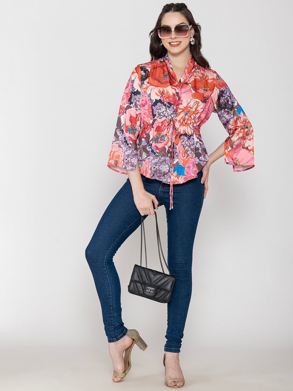 Side angle of pink floral satin top with long buttoned cuffs