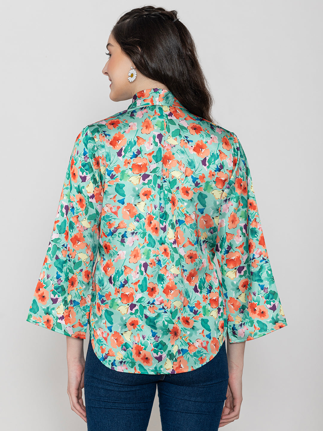 Lifestyle shot of green floral satin top styled with denim