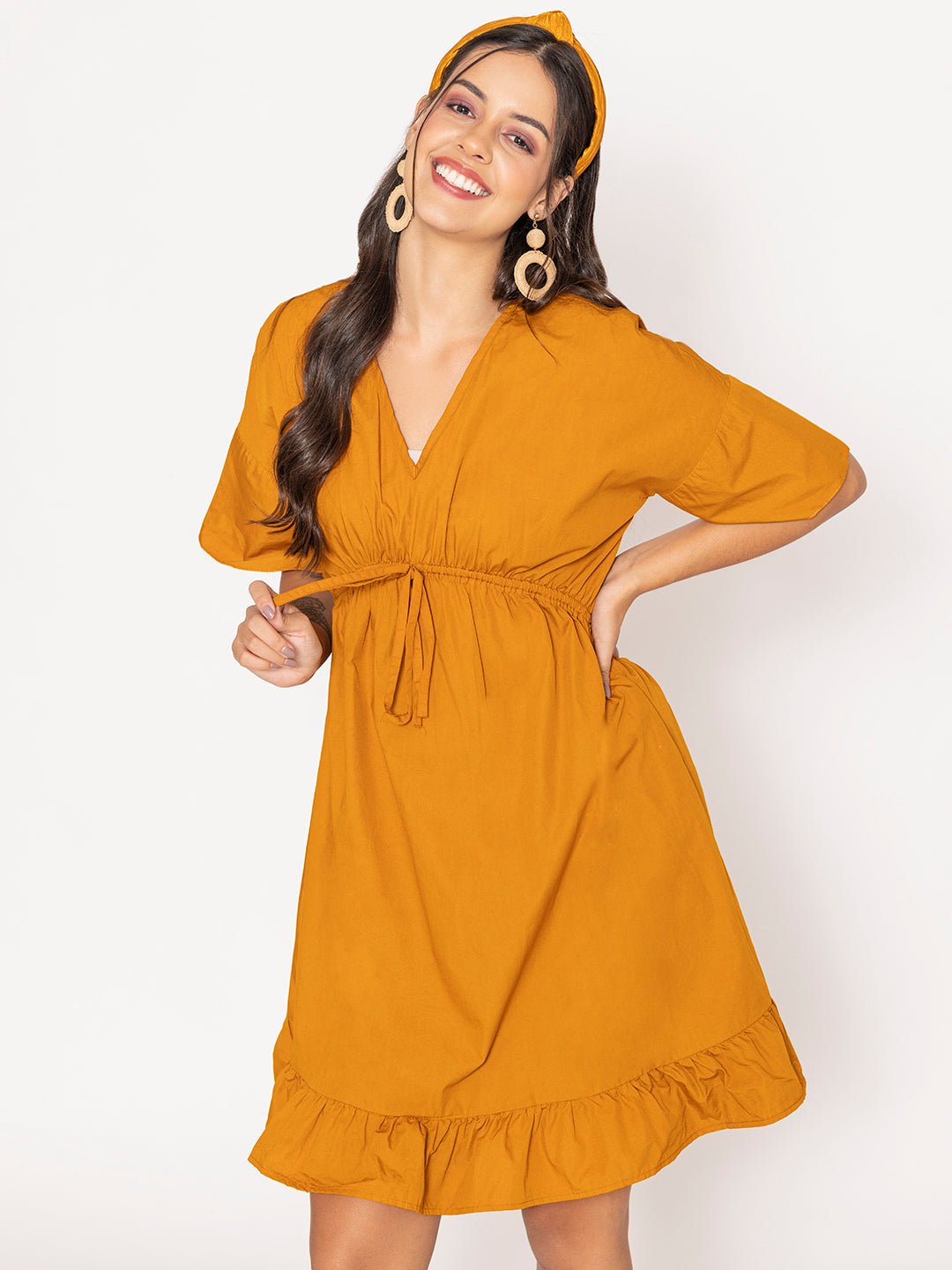 Lifestyle shot of woman wearing tan brown cotton dress