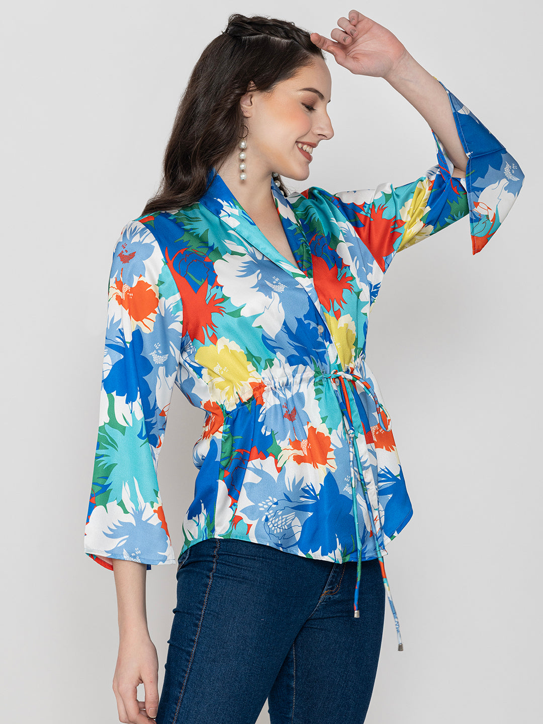 Lifestyle shot of blue floral satin top styled with denim