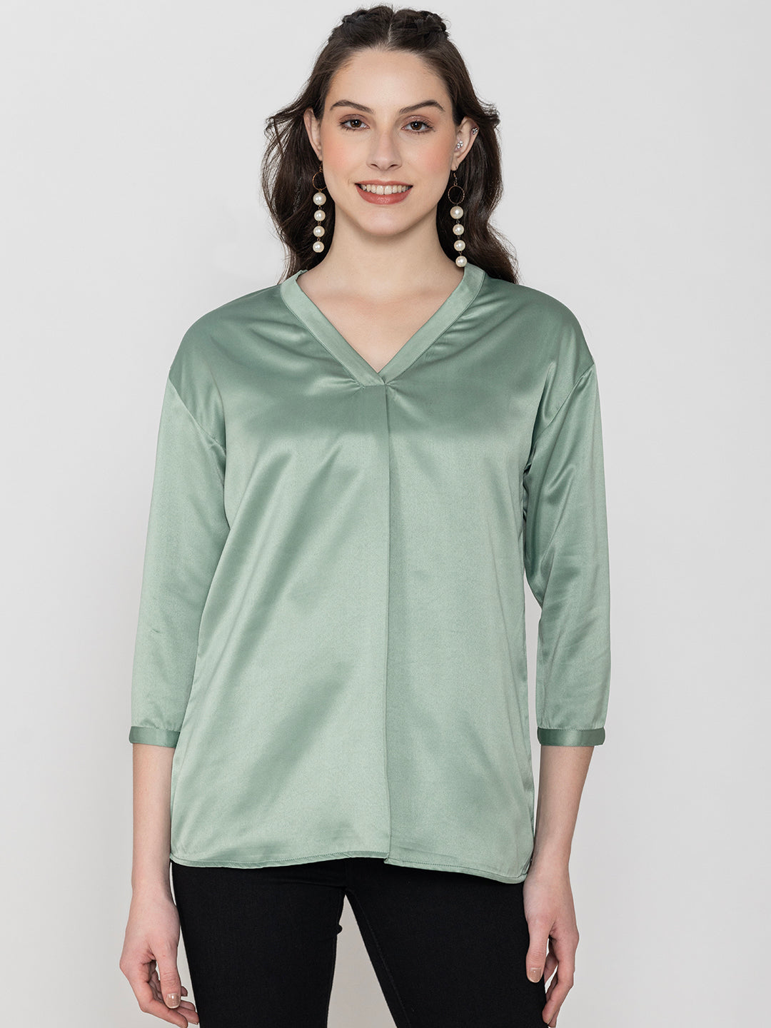 Detail shot of v-neck on light green satin top