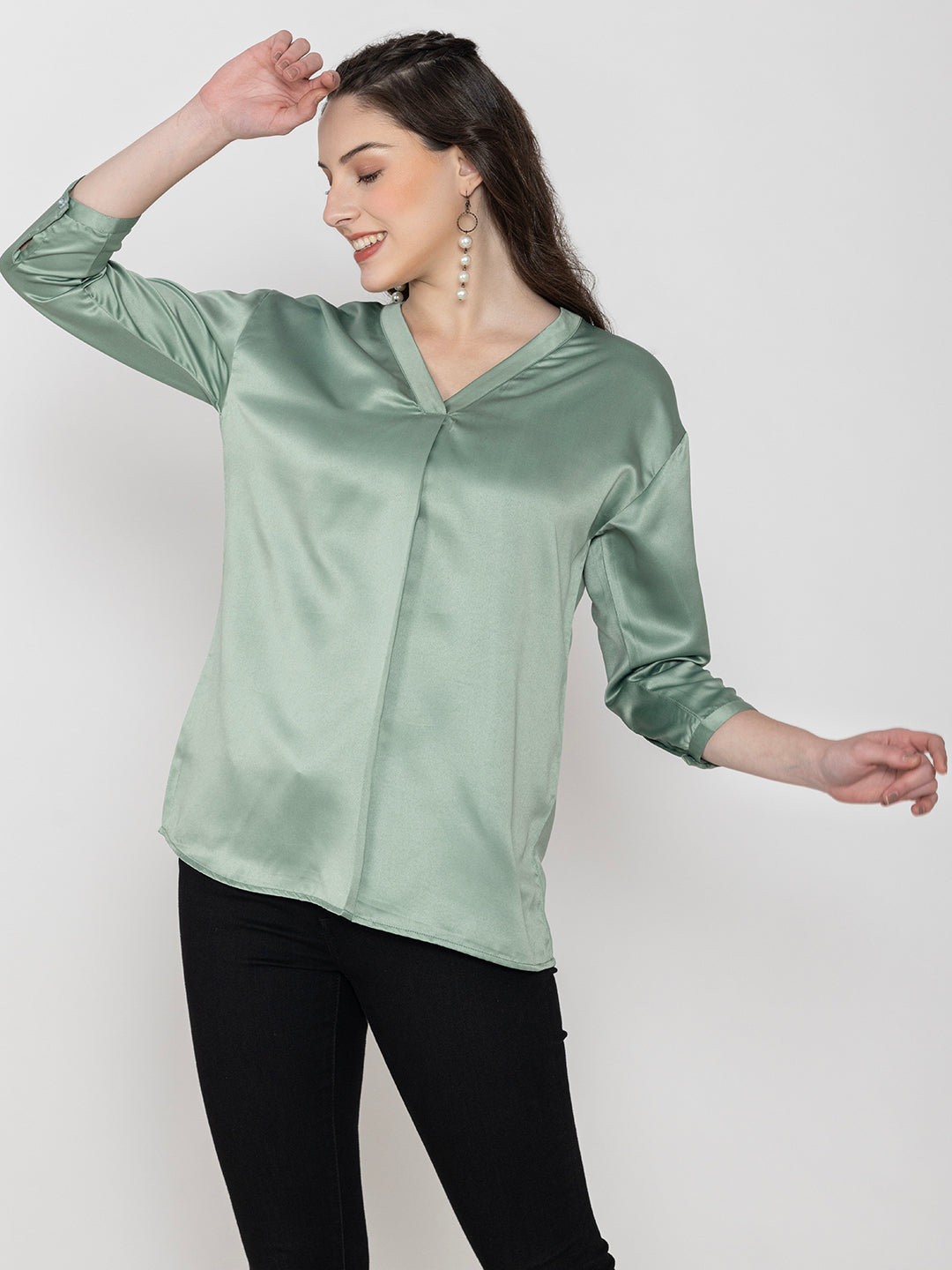 Lifestyle shot of light green satin top styled