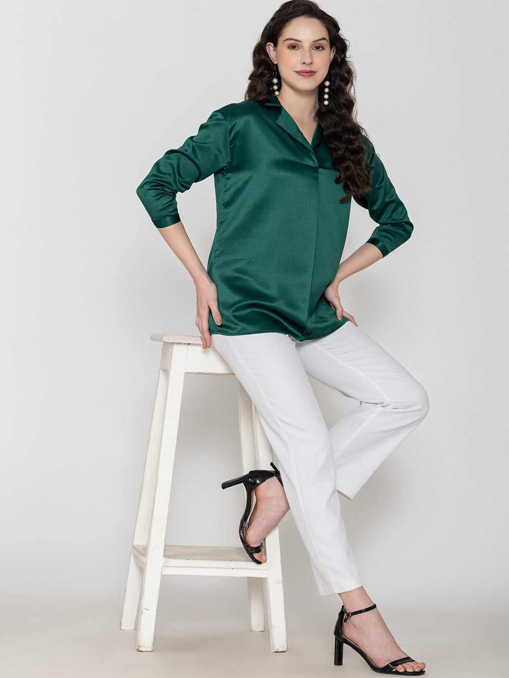 Side view of dark green satin top with long buttoned cuffs