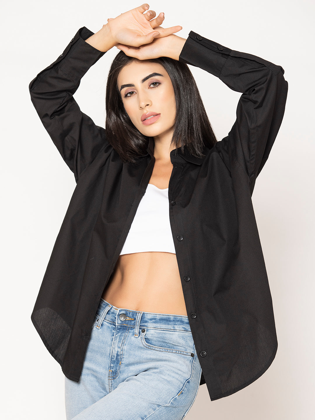 Lifestyle shot of woman wearing black cotton poplin oversized shirt