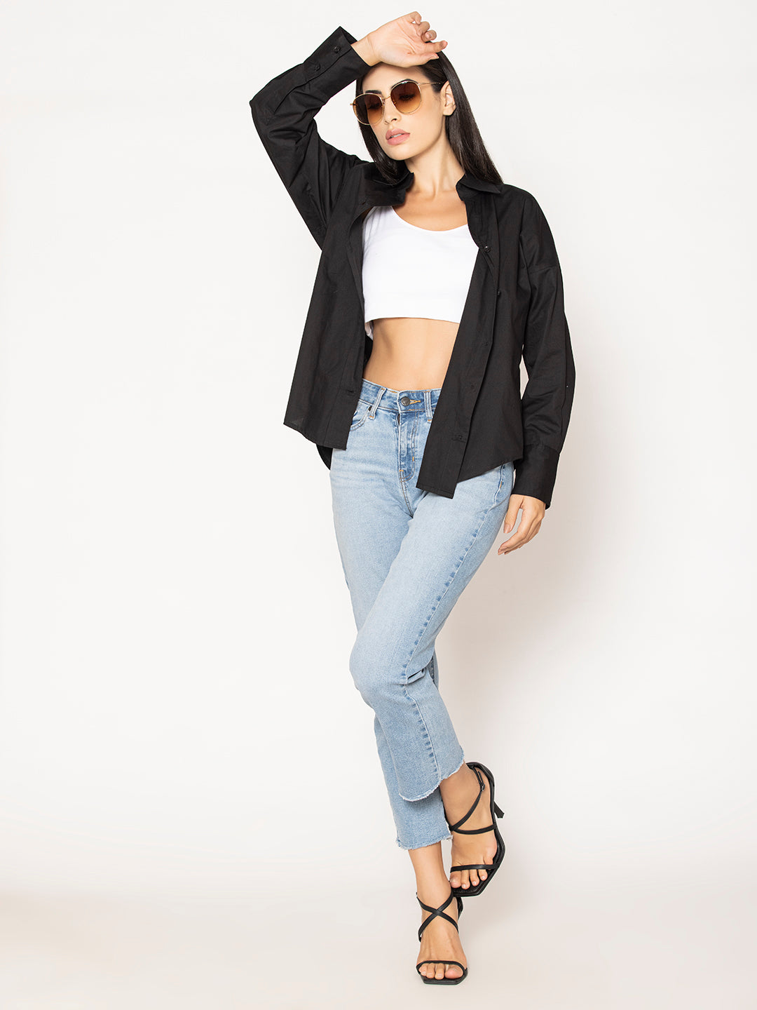 Back view of black cotton oversized shirt with curved hem