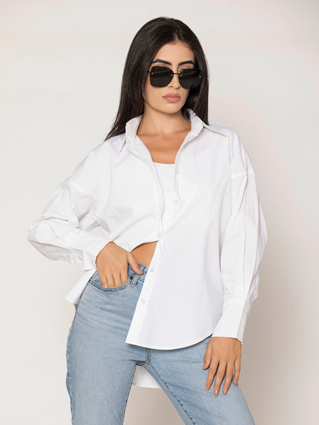 Side profile of oversized white cotton poplin shirt showing drop-shoulder cut