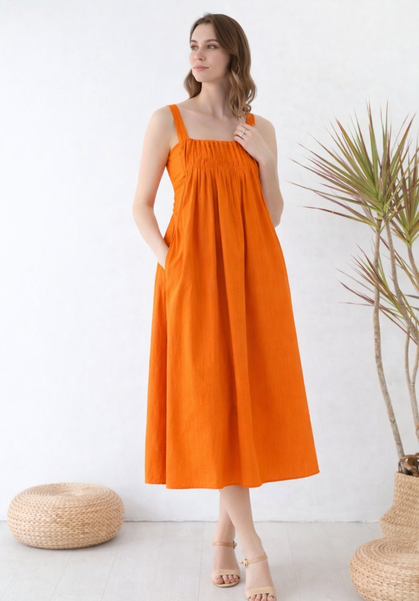 Close-up of pleated front detailing on rust cotton A-line dress