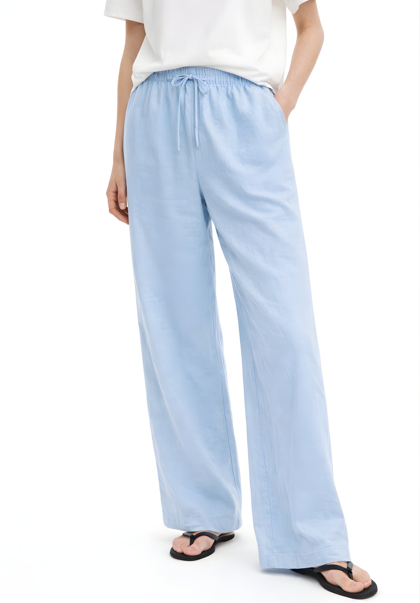 Detail of side pocket on sky blue baggy linen trousers