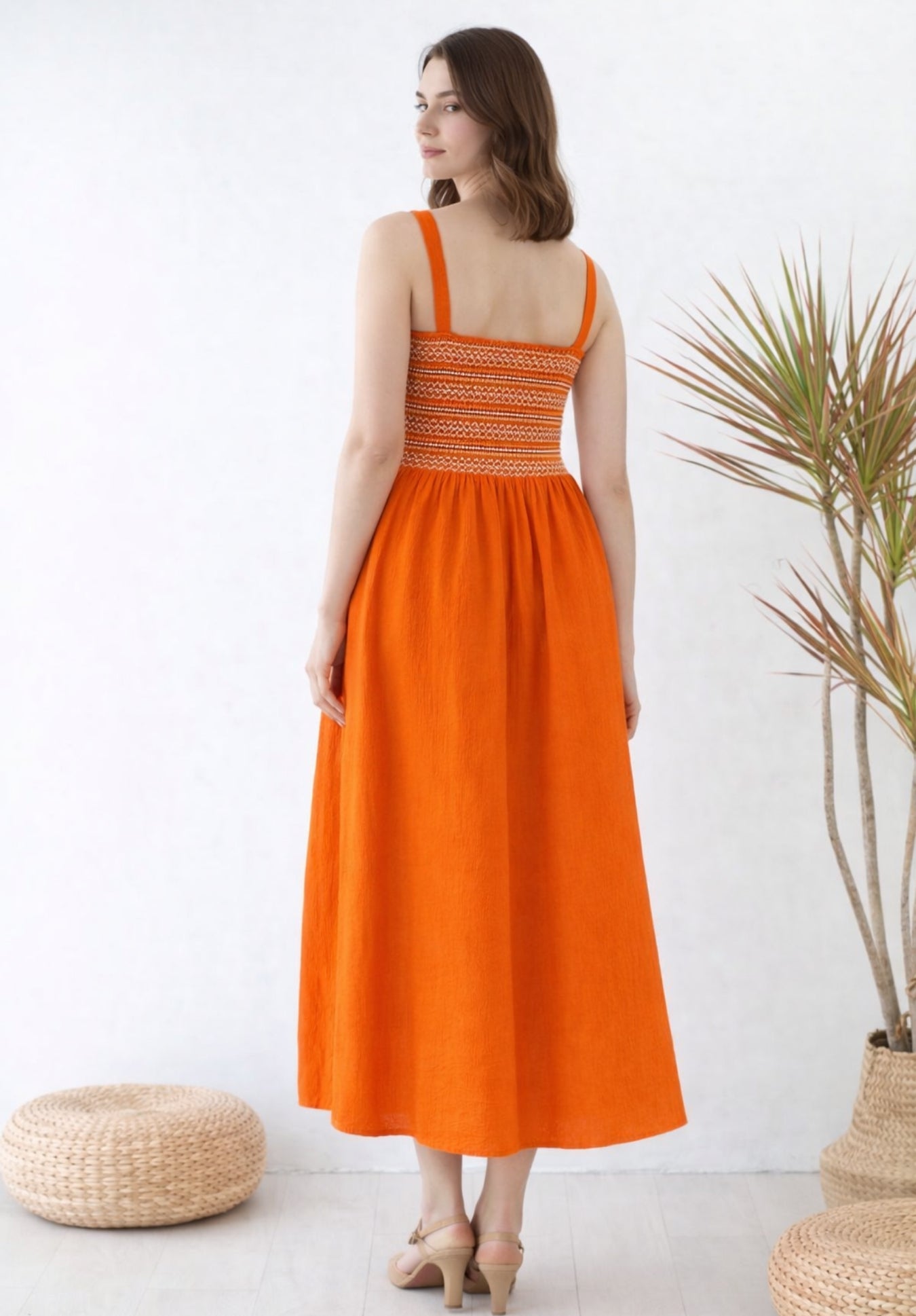 Close-up of smocked waist detailing on rust pure cotton dress