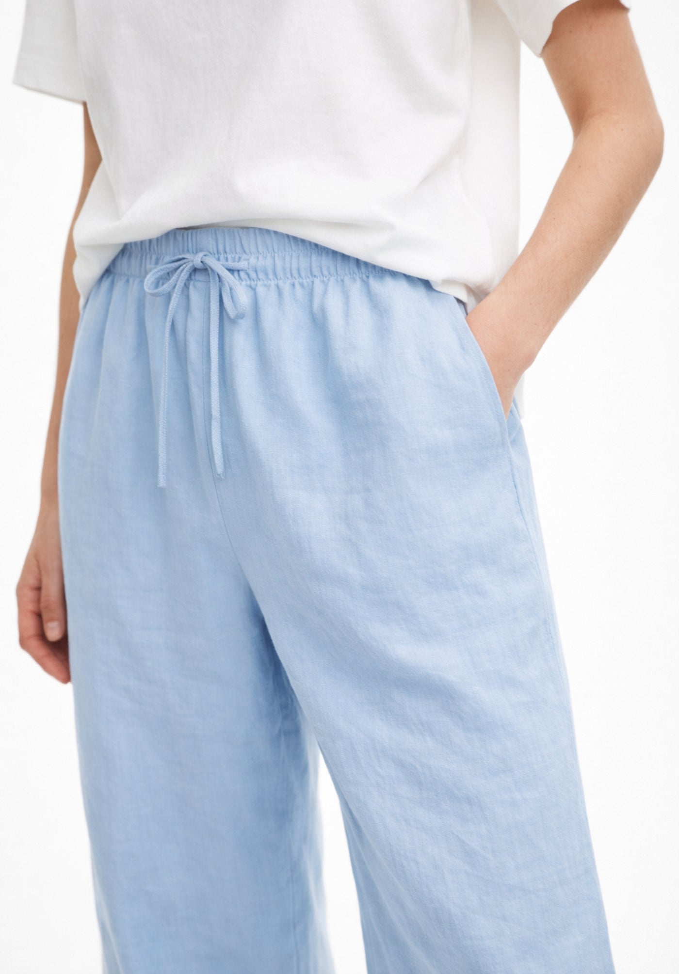 Lifestyle shot of model wearing sky blue baggy trousers