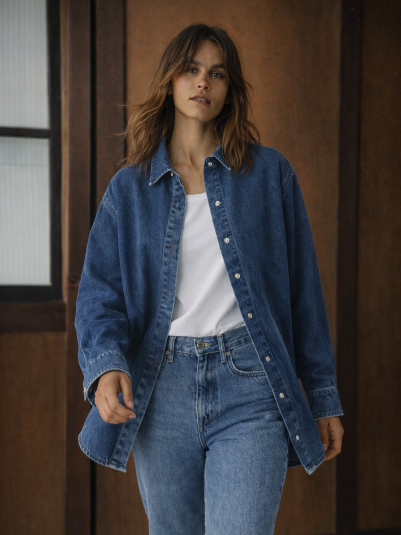 Back view of dark blue oversized denim shirt with curved hem