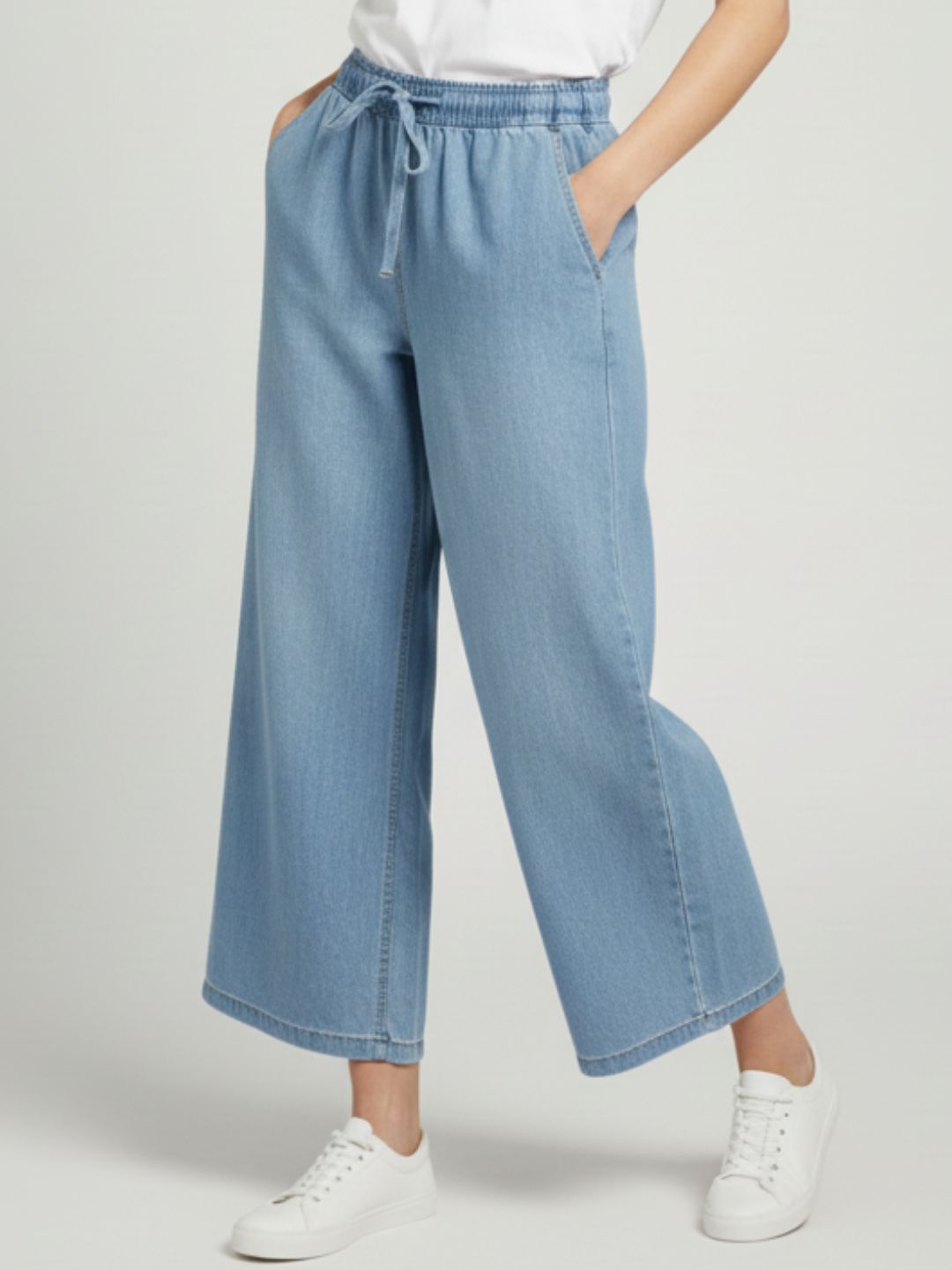 Light blue denim drawstring trousers full-length on model
