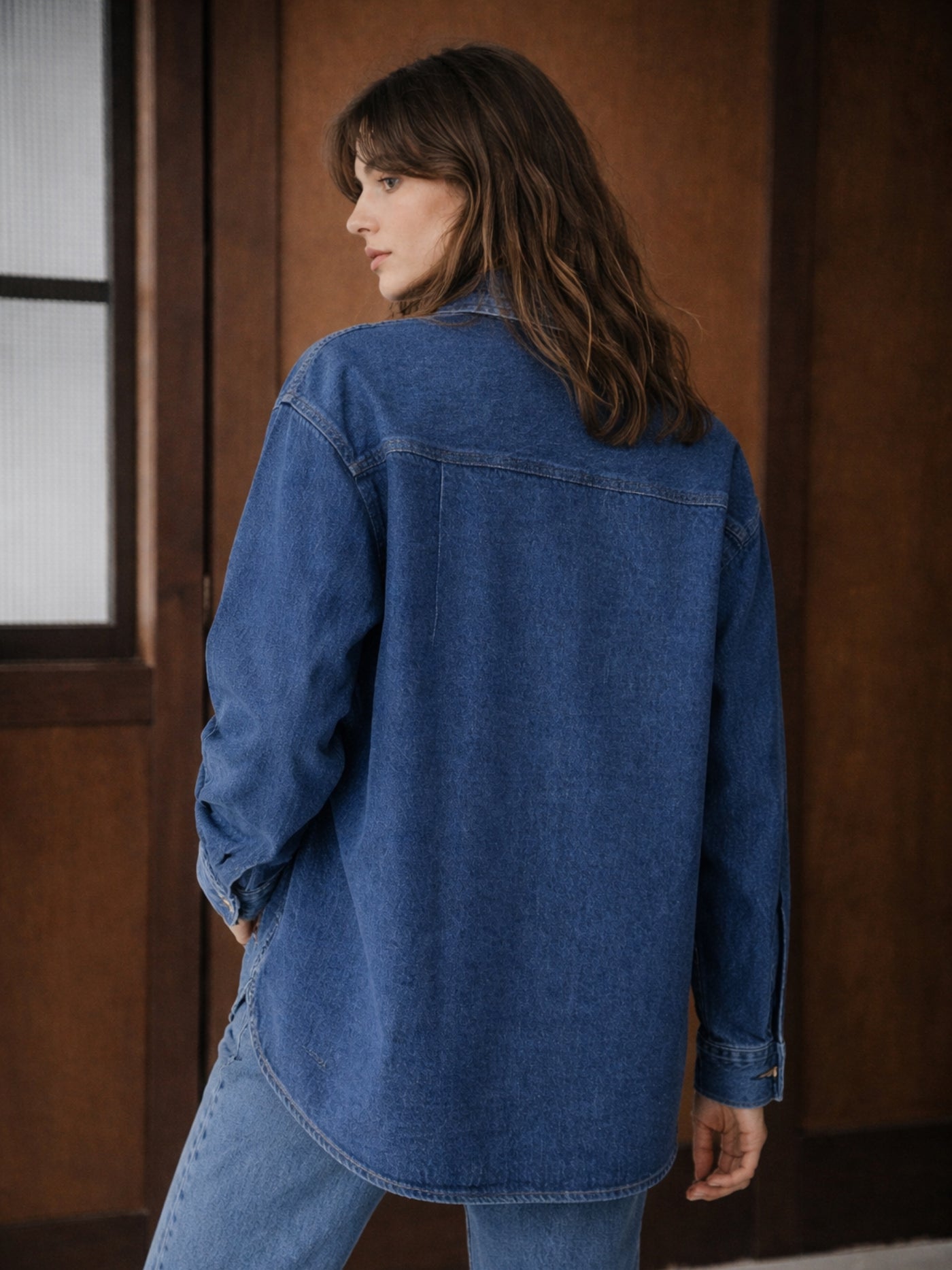 Lifestyle shot of dark blue denim shirt styled open over a tee