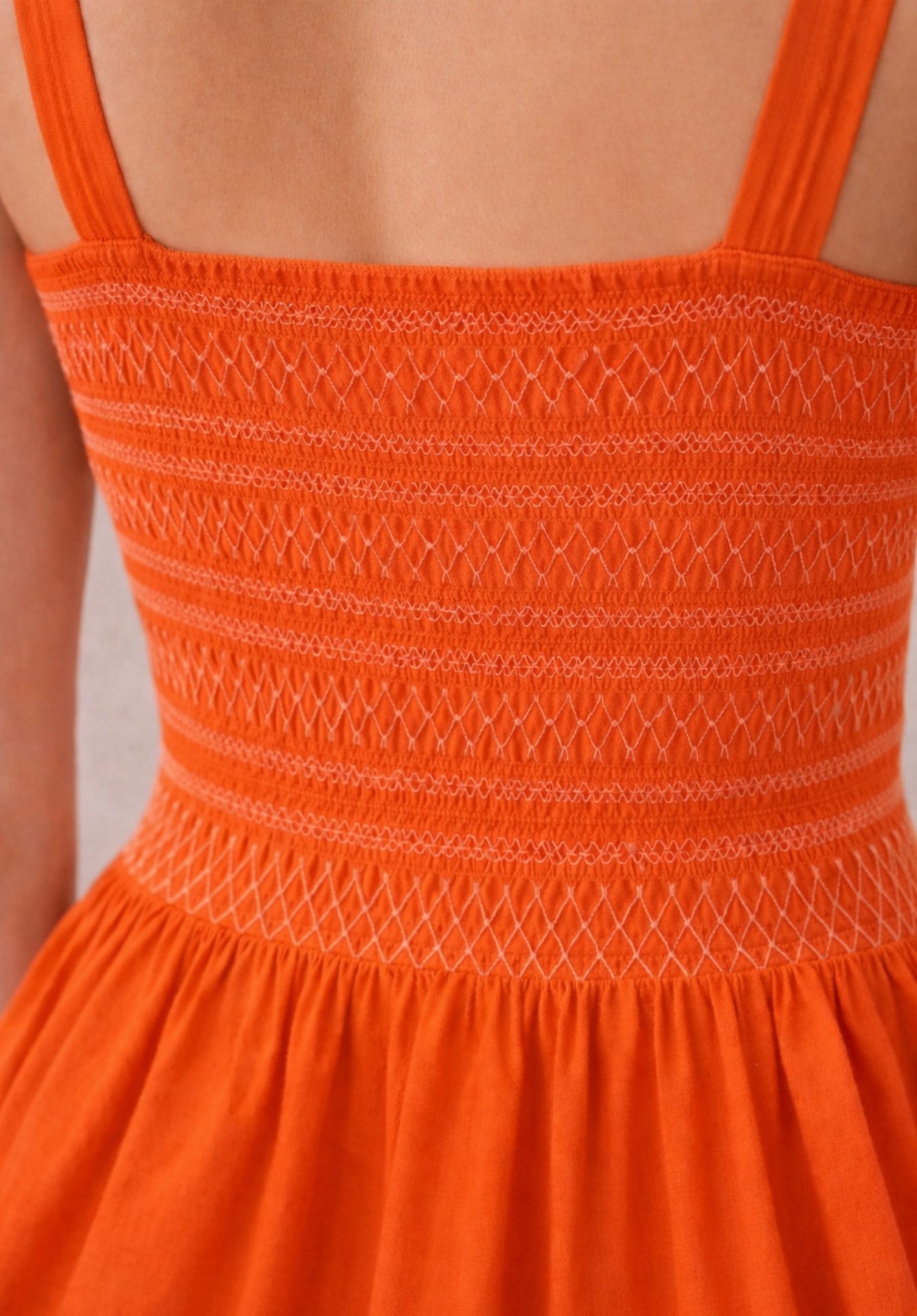 Detail shot showing fabric texture of rust pleated pure cotton dress