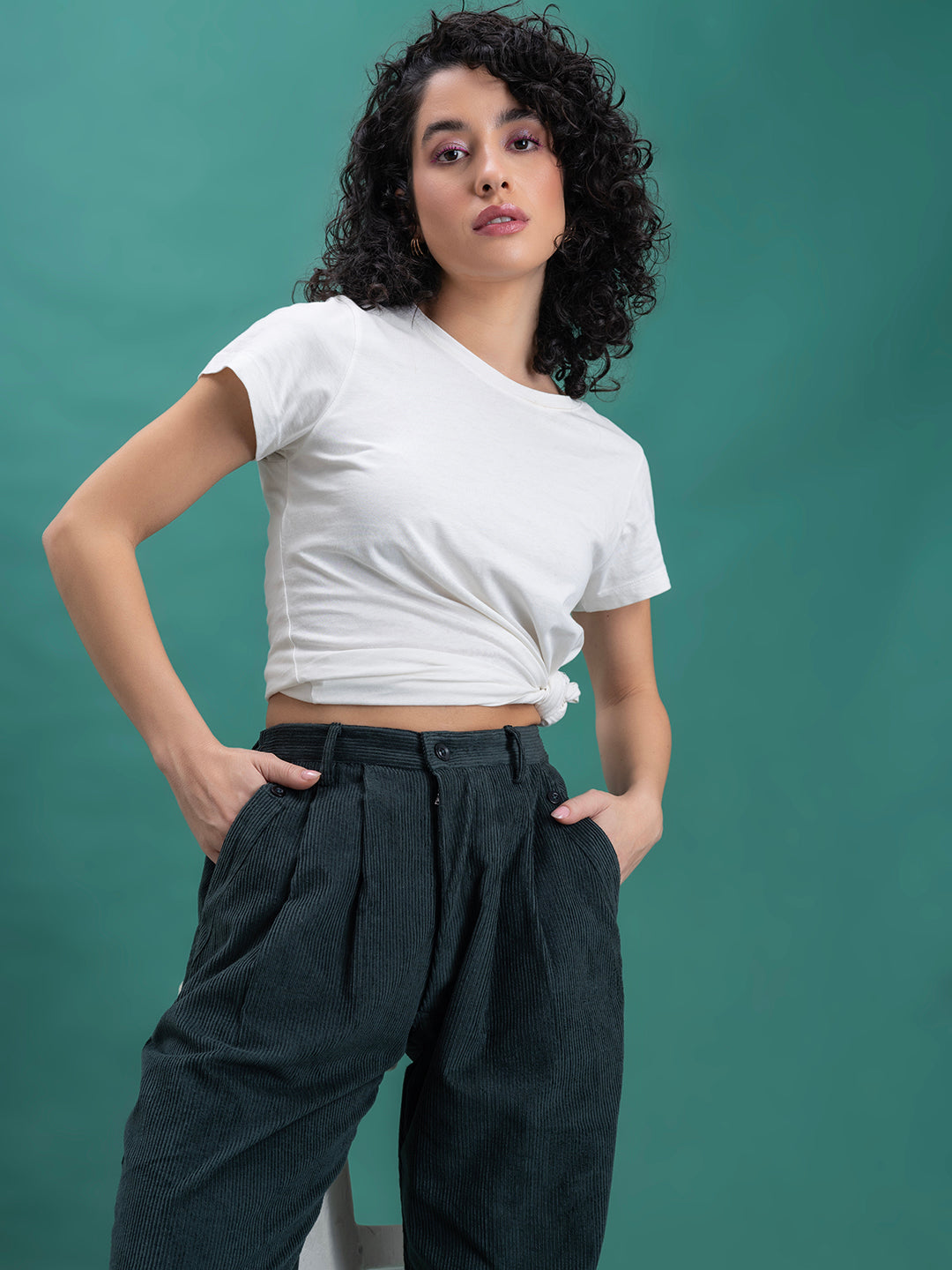 Full outfit view of green corduroy baggy trousers paired with top