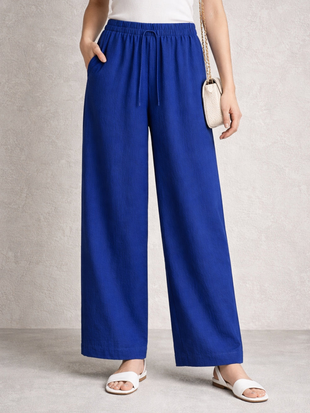 Side view of blue linen blend baggy trousers with drawstring waist