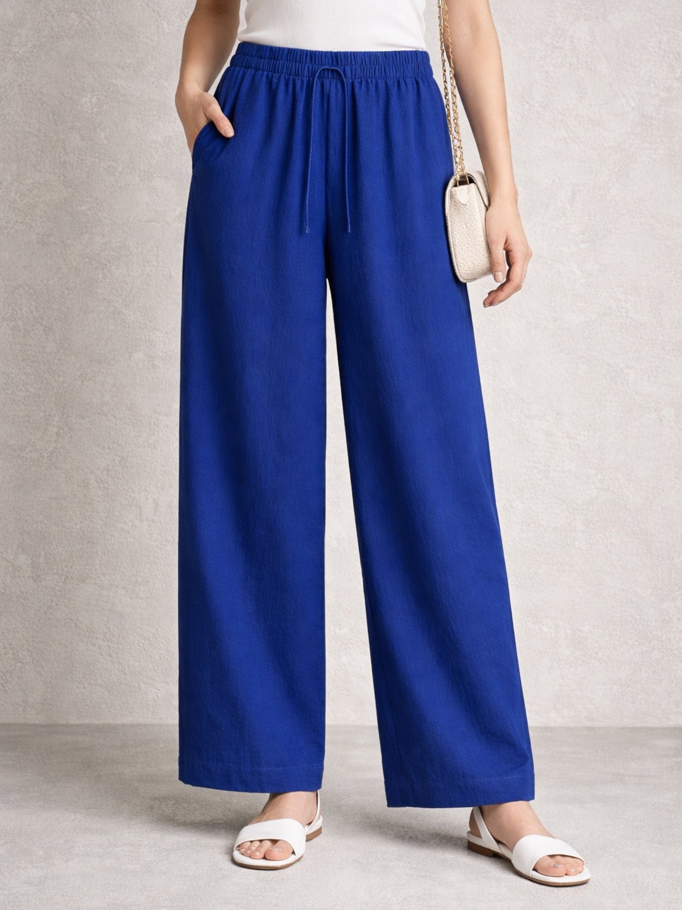 Side view of blue linen blend baggy trousers with drawstring waist