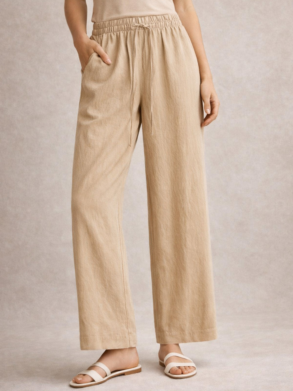 Side view of beige linen blend baggy trousers with drawstring