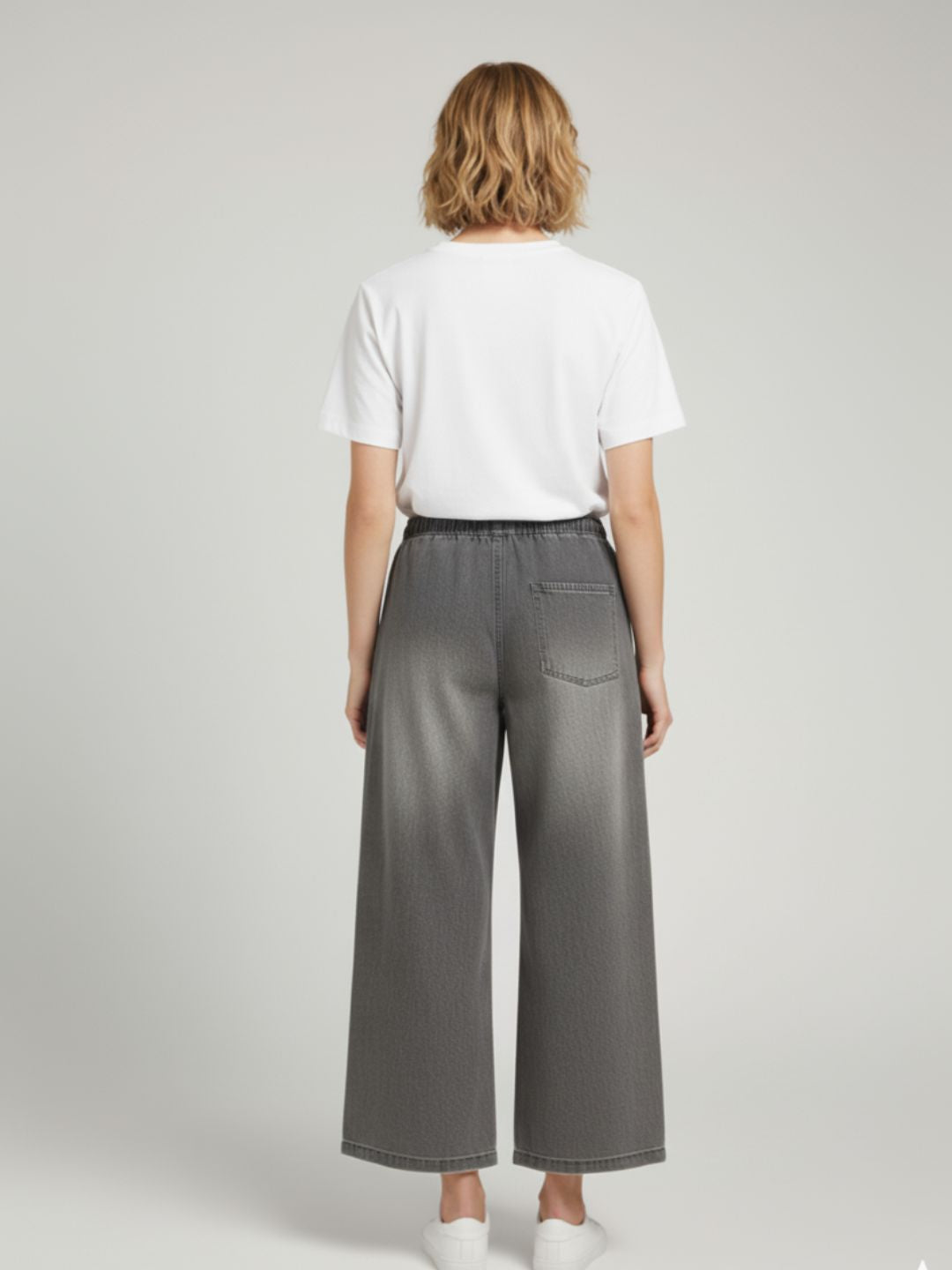 Close-up of drawstring waistband on grey cotton trousers