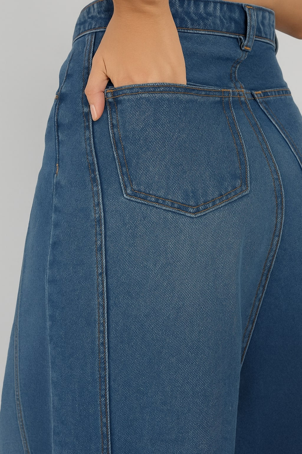Close-up of denim fabric and front pocket on blue skirt