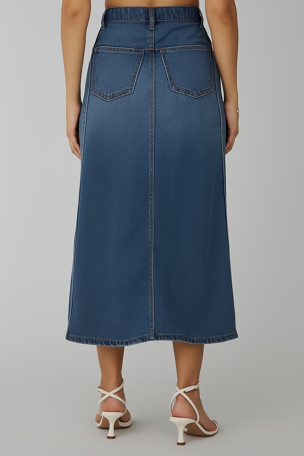 Detail shot of mid-rise waistband on blue denim skirt
