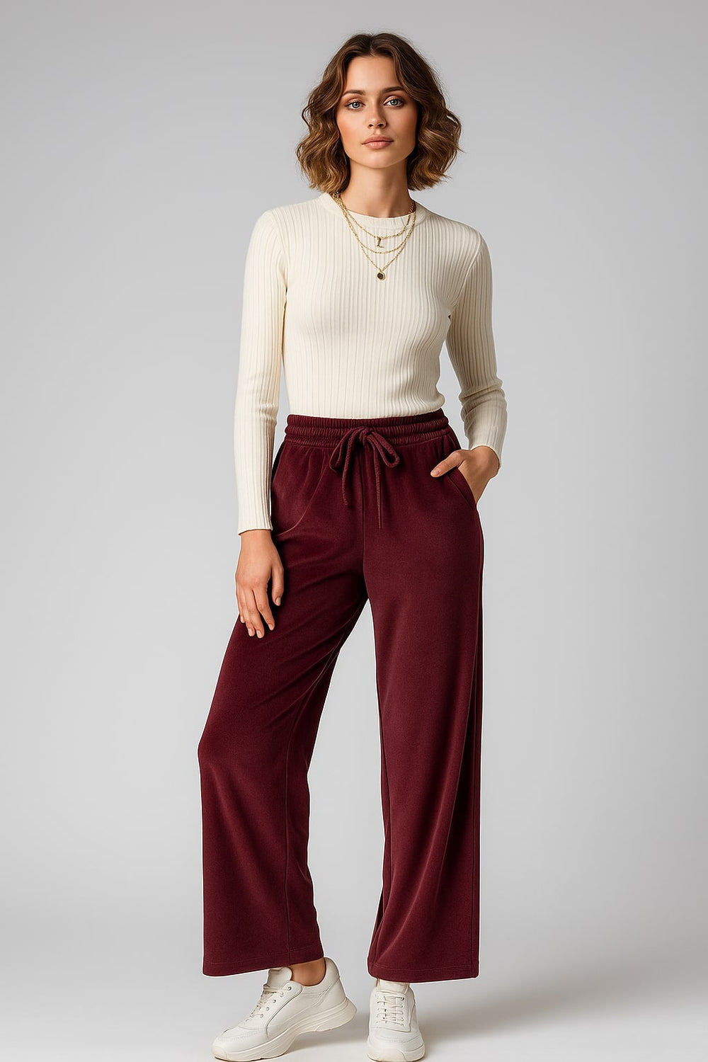 Side angle of maroon velvet trousers showing mid-rise waist