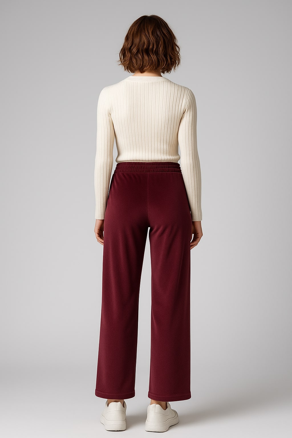 Lifestyle shot of maroon velvet drawstring trousers
