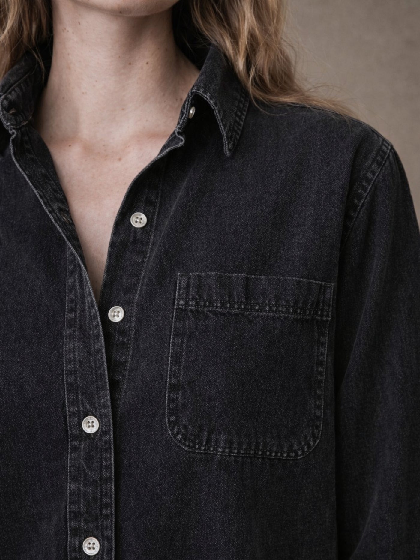Detail shot of spread collar on black denim shirt