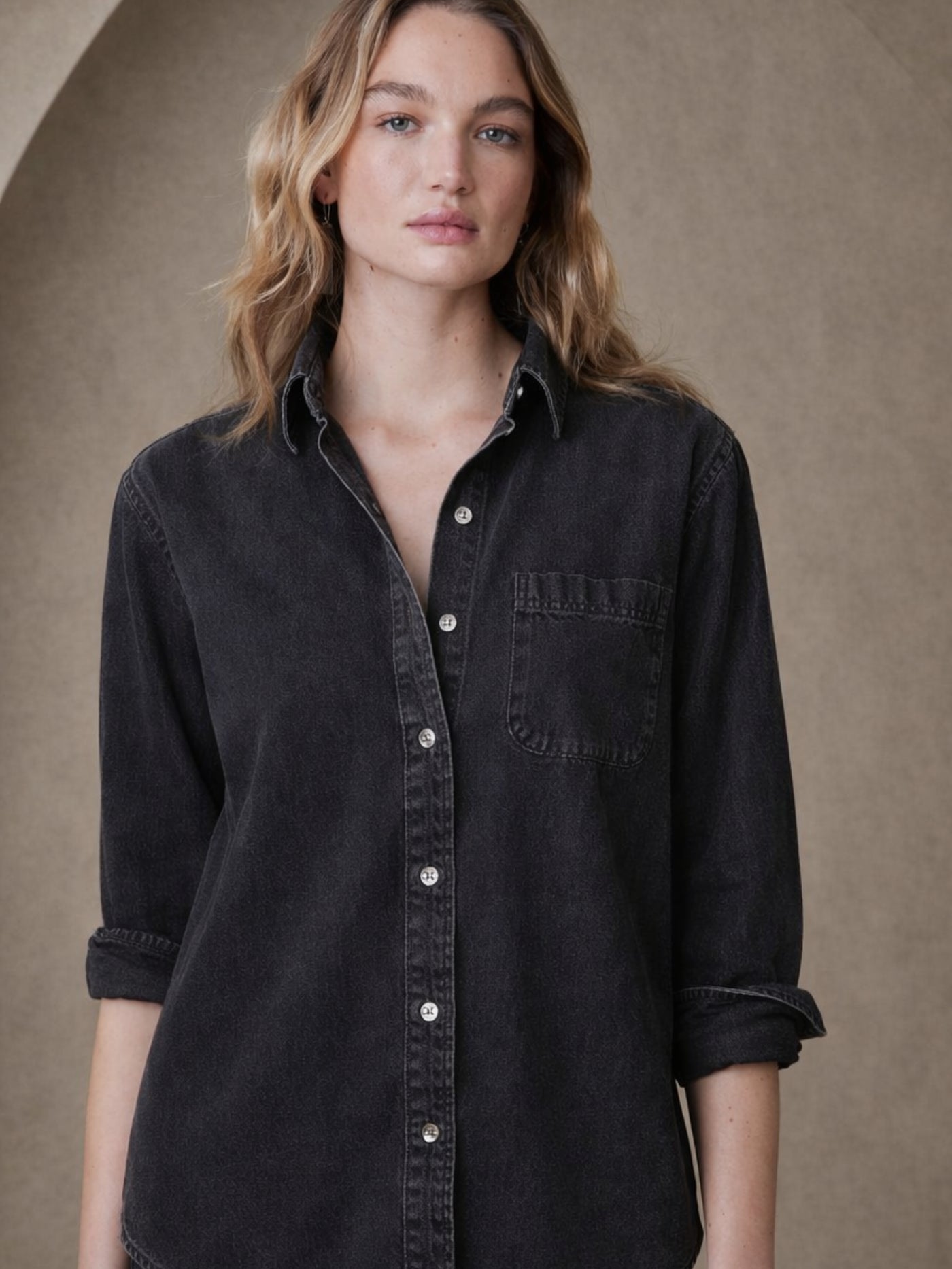 Lifestyle shot of black denim shirt styled open over a tee