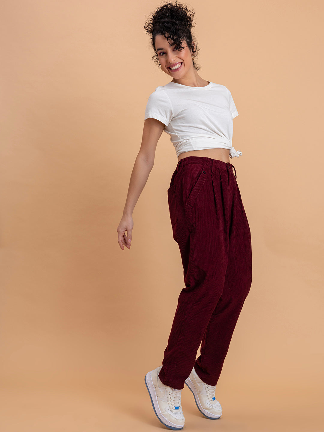 Full outfit view of maroon corduroy baggy trousers paired with top