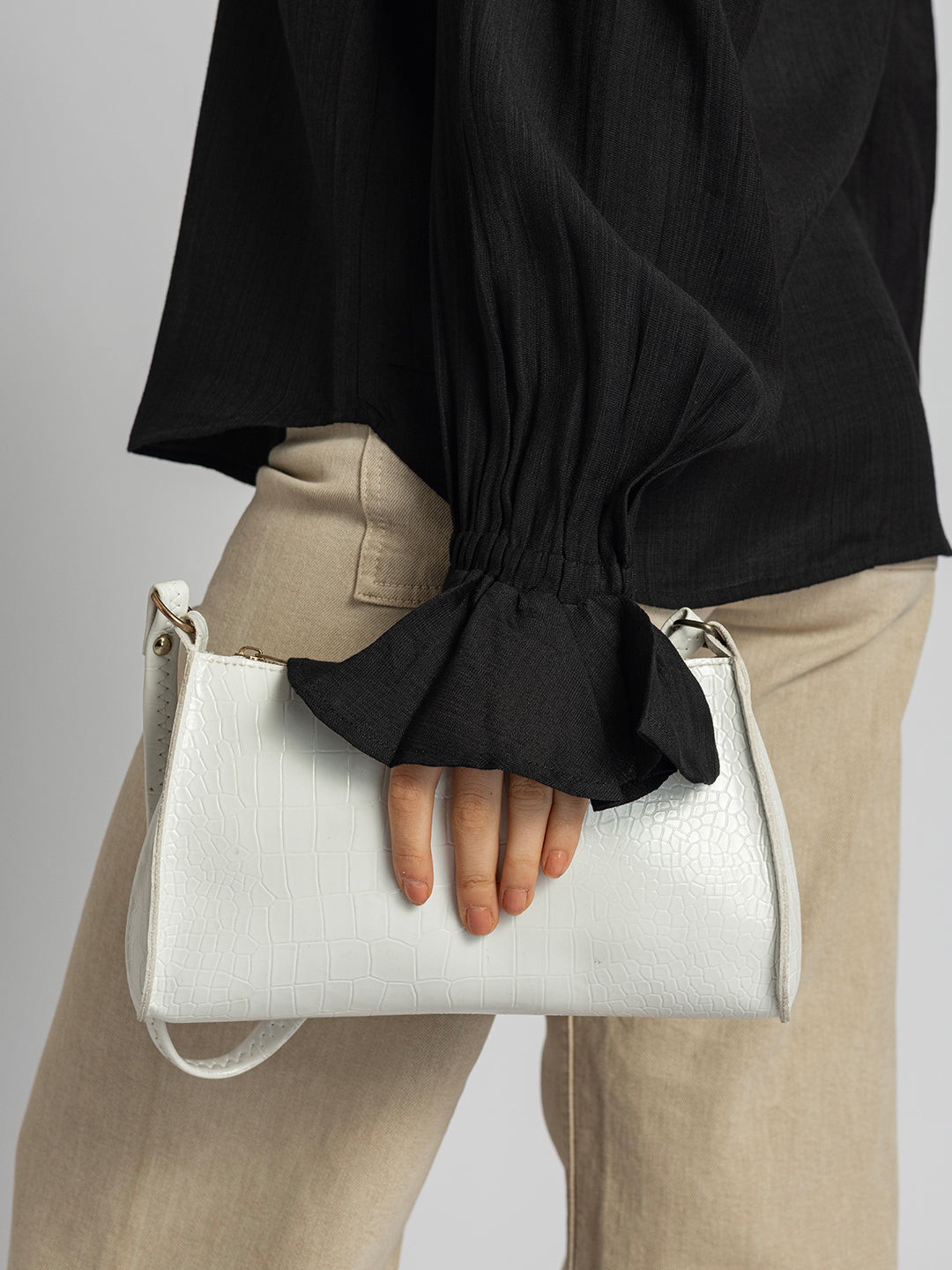 Close-up of ruffled cuff detail on black shirt