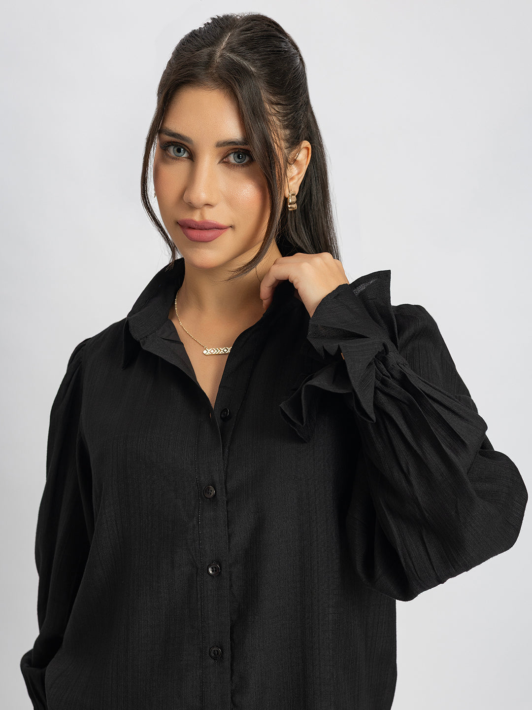 Hem detail of black ruffled cuff shirt