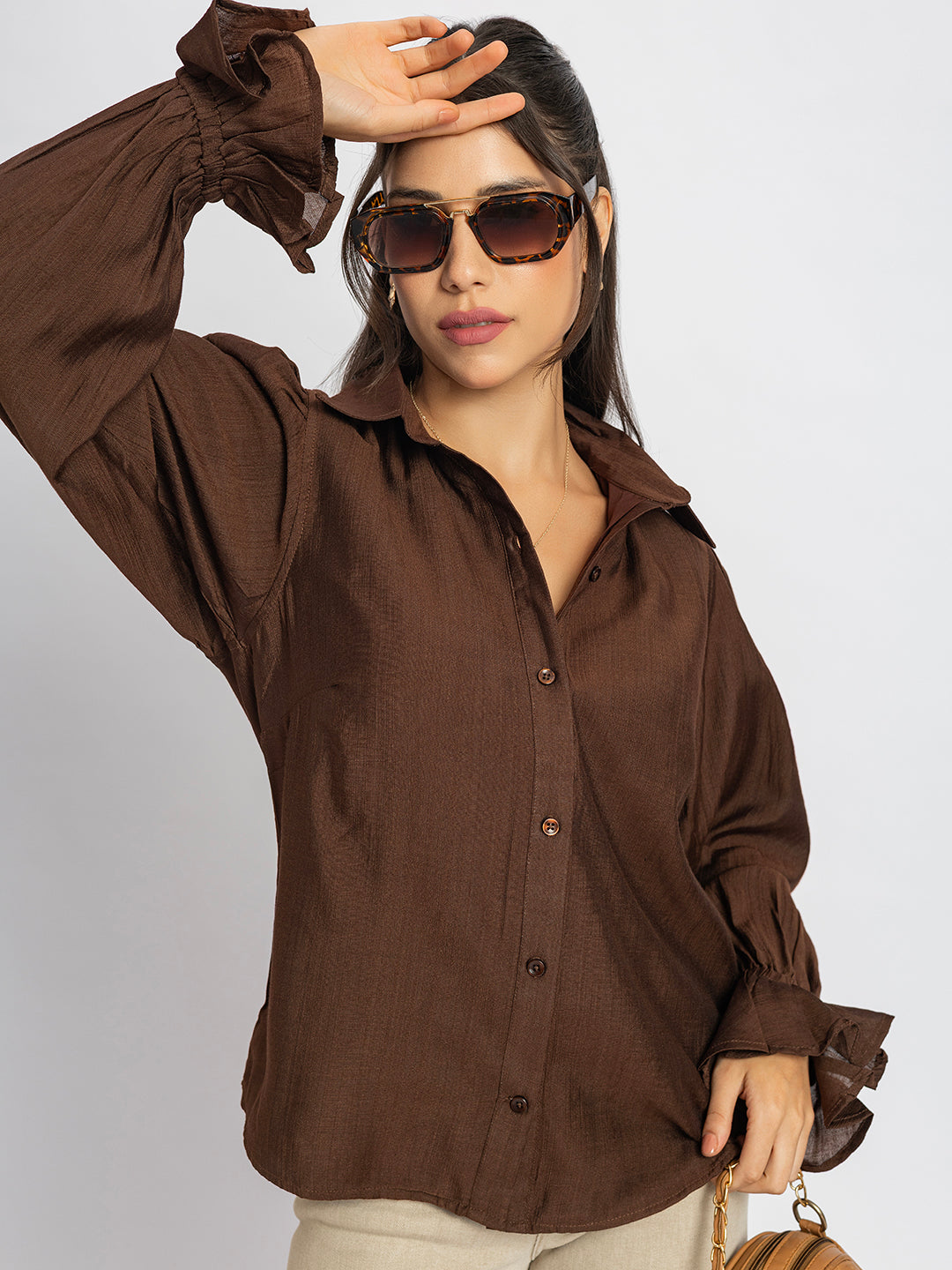 Detail view of long sleeves on brown ruffled cuff shirt