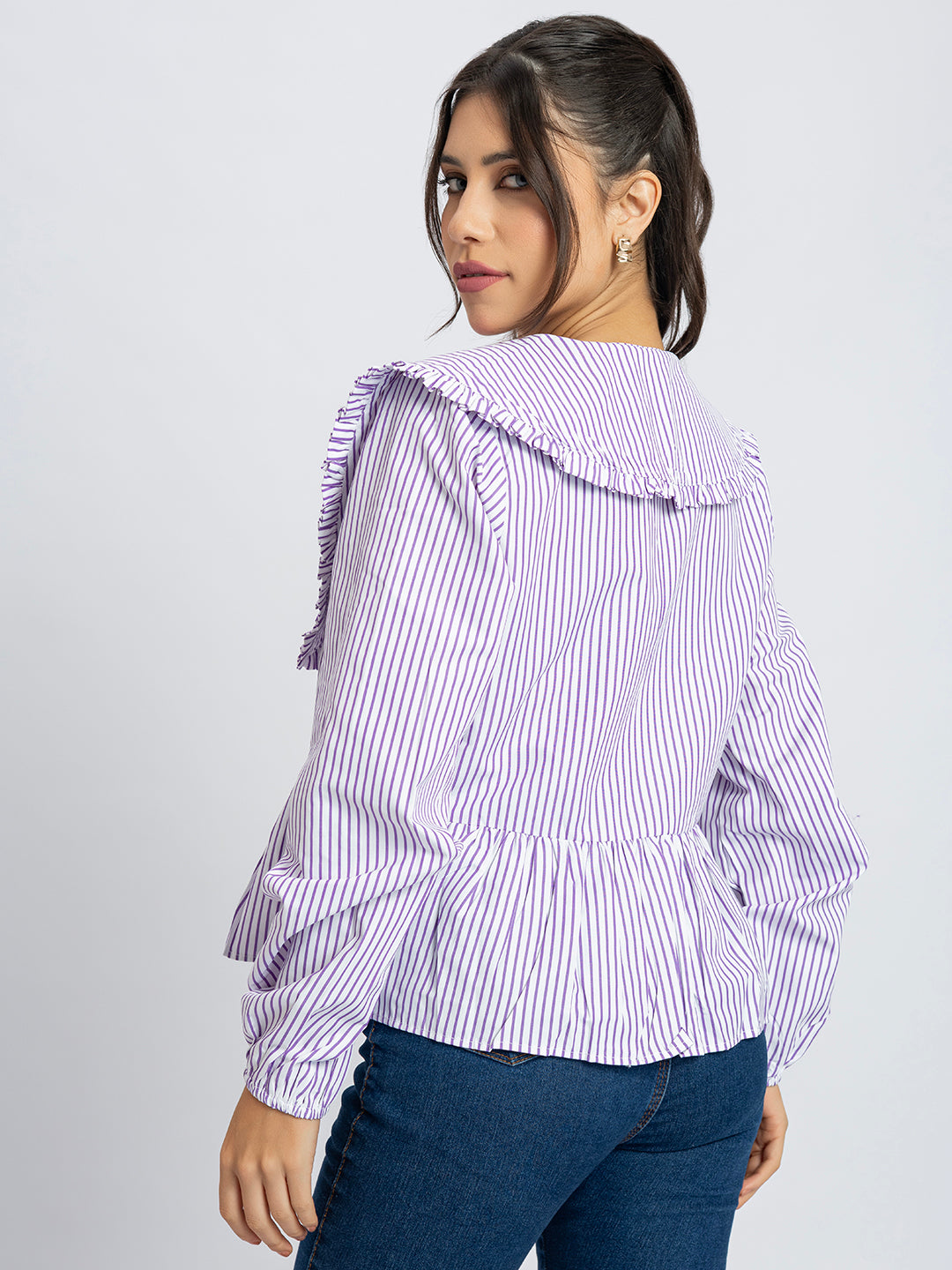 Lifestyle shot of white and purple striped peplum top