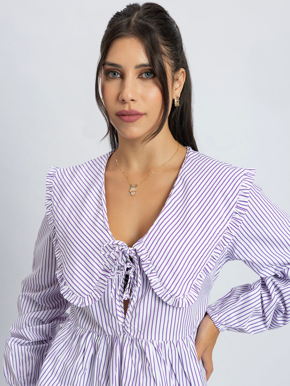 Side view of white and purple peplum top with frill collar