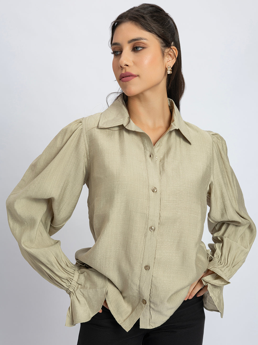 Lifestyle shot of beige ruffled cuff shirt styled with denim