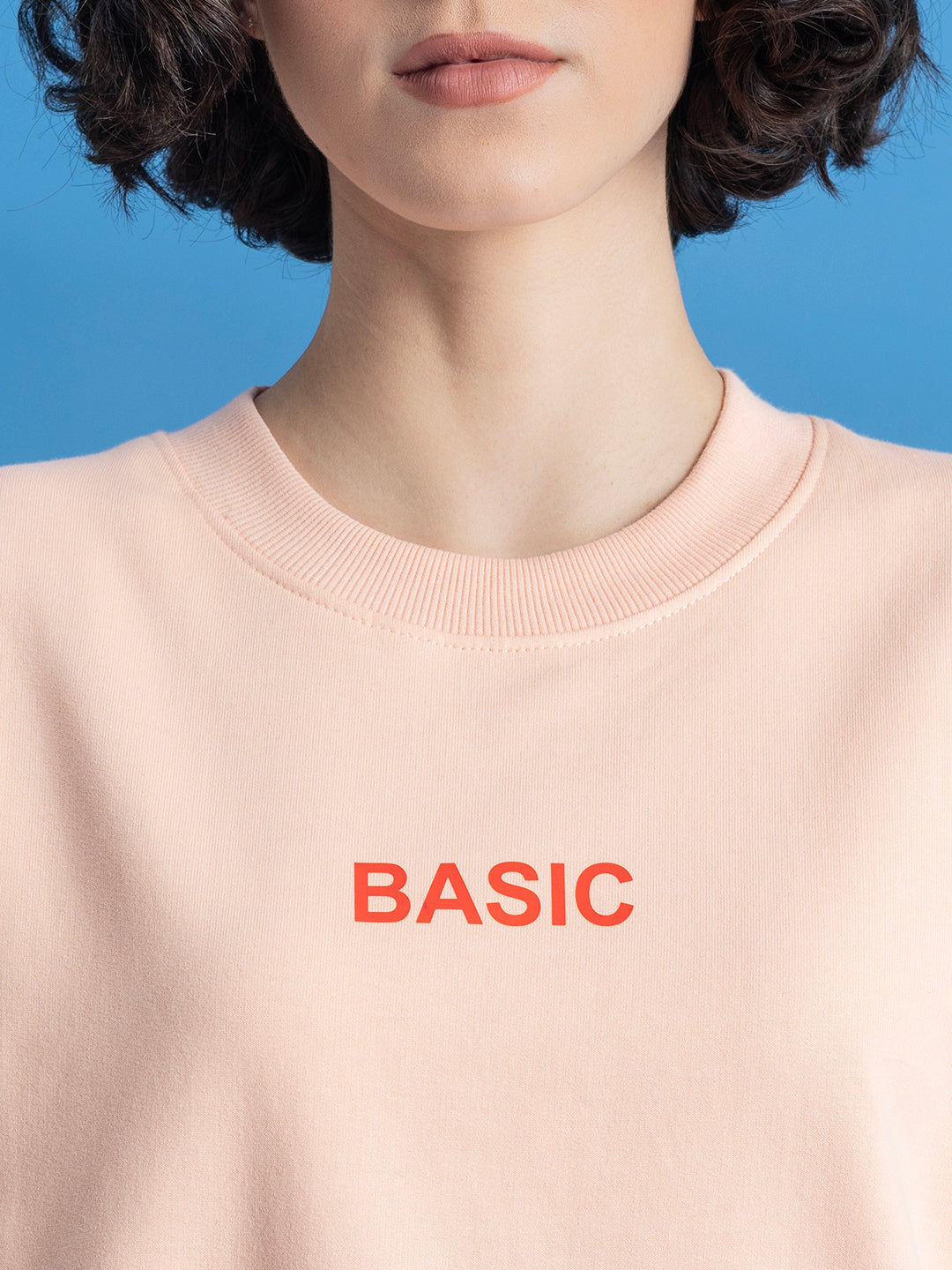 Close-up of ribbed cuff on peach sweatshirt