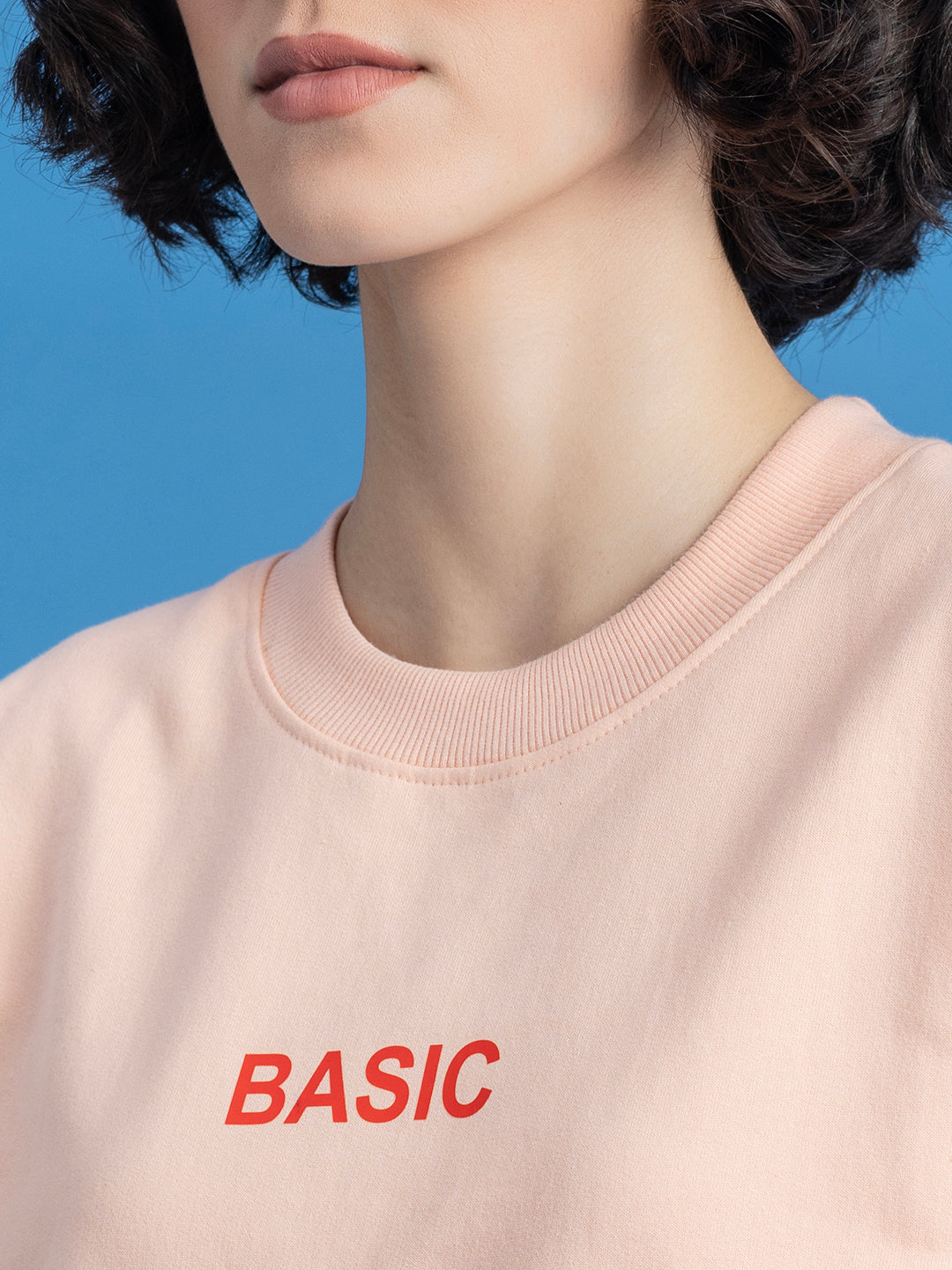 Detail of crew neck on peach cotton blend sweatshirt