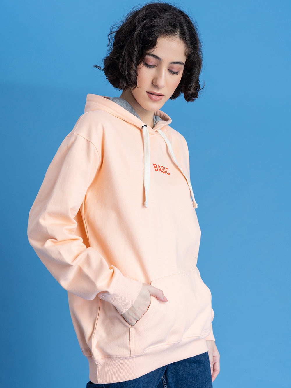 Side view of peach hoodie showing relaxed fit