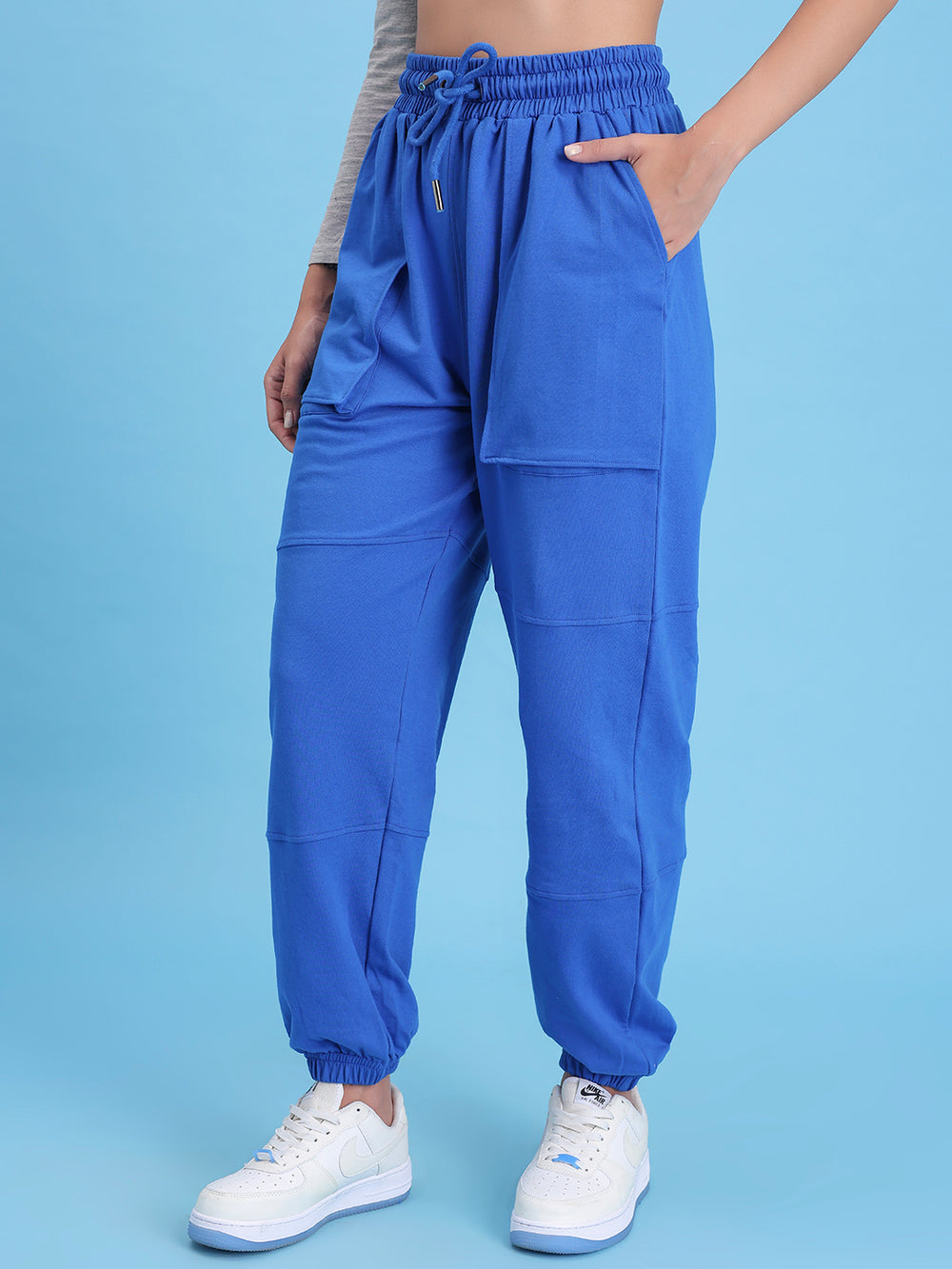 Side view of blue cotton joggers showing pocket and elastic waist