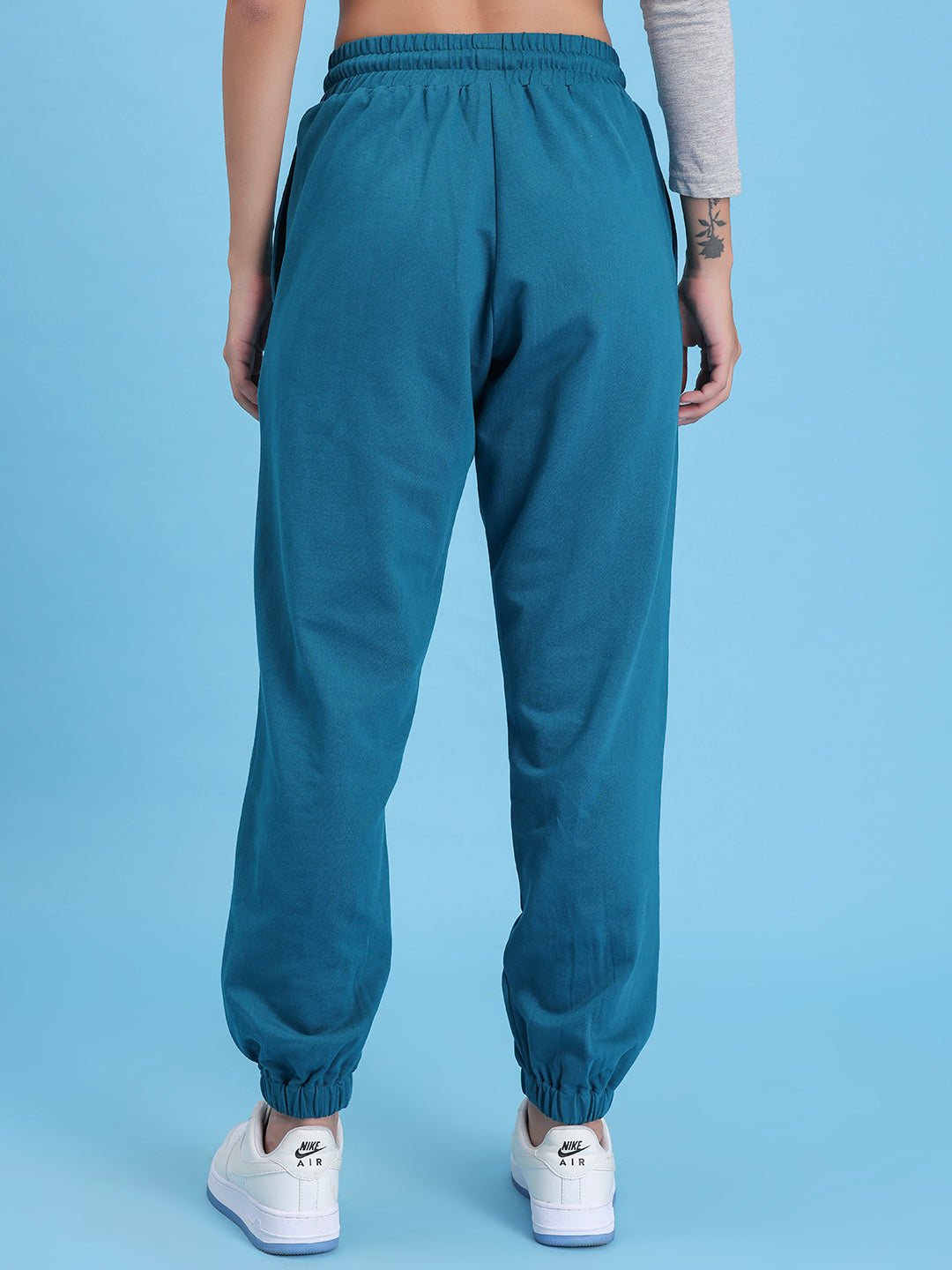 Close-up of elastic waistband on teal knit joggers