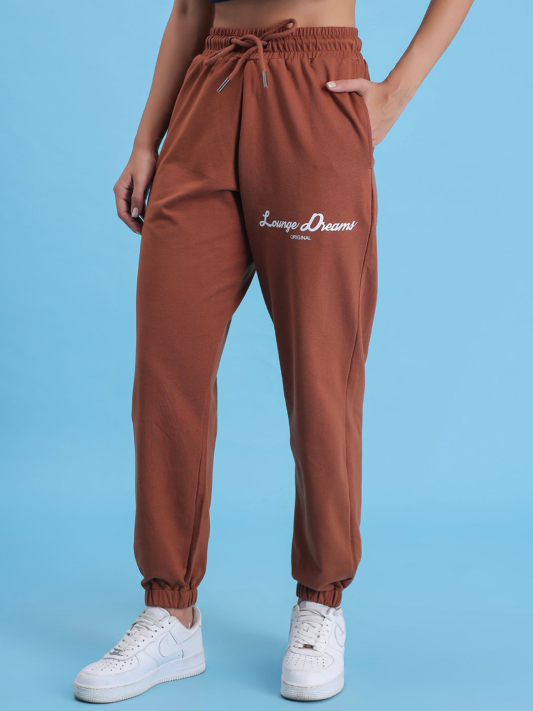 Lifestyle shot of brown joggers styled with a tee