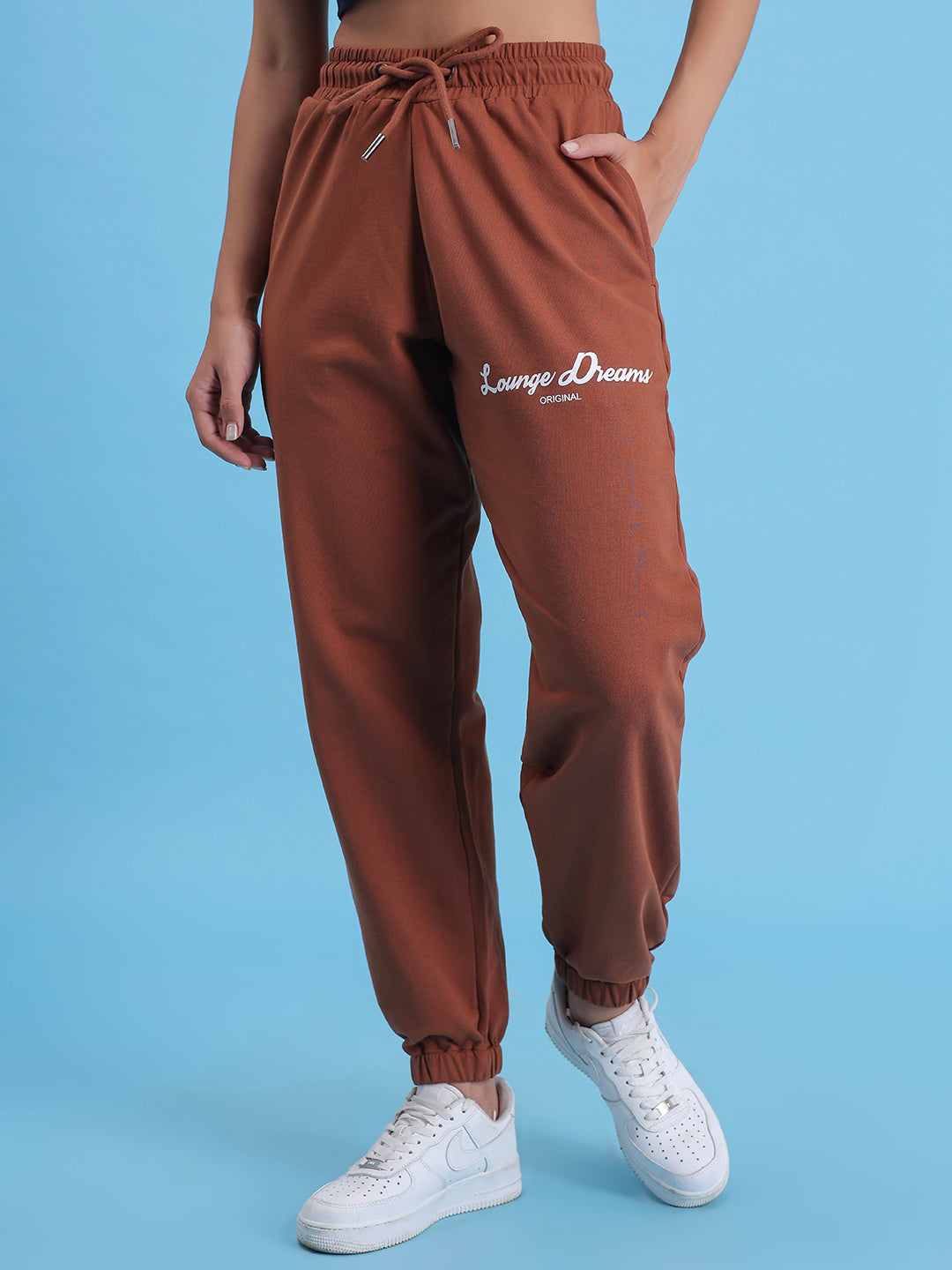 Detail of cuffed hem on brown cotton joggers