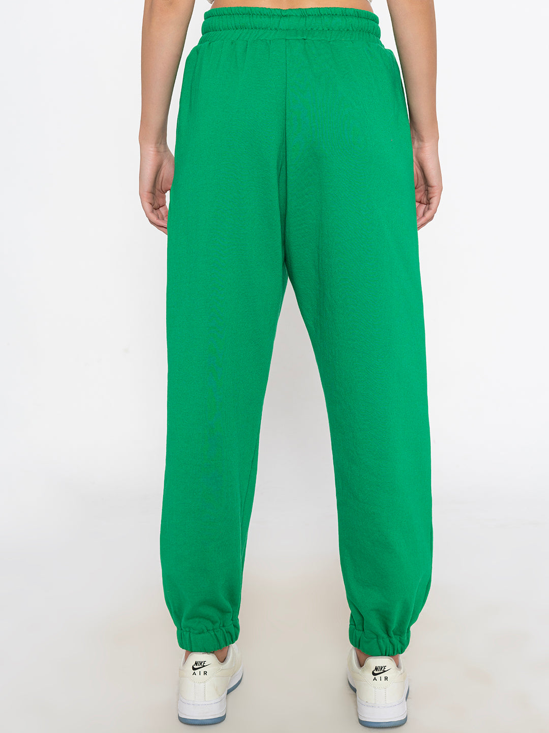 Back view of green joggers showing relaxed silhouette and pocket detail