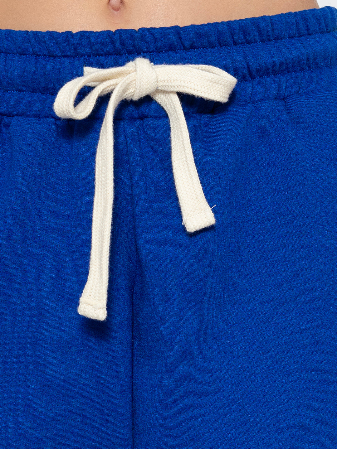 Lifestyle shot of blue joggers styled with white tee