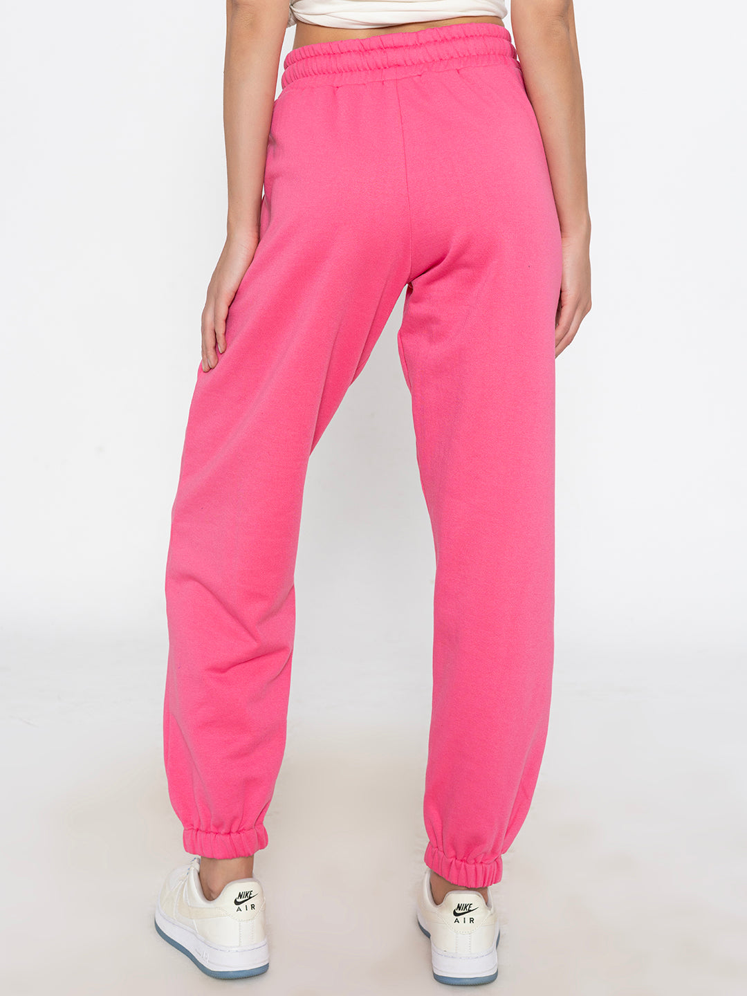 Lifestyle shot of pink joggers styled with white tee