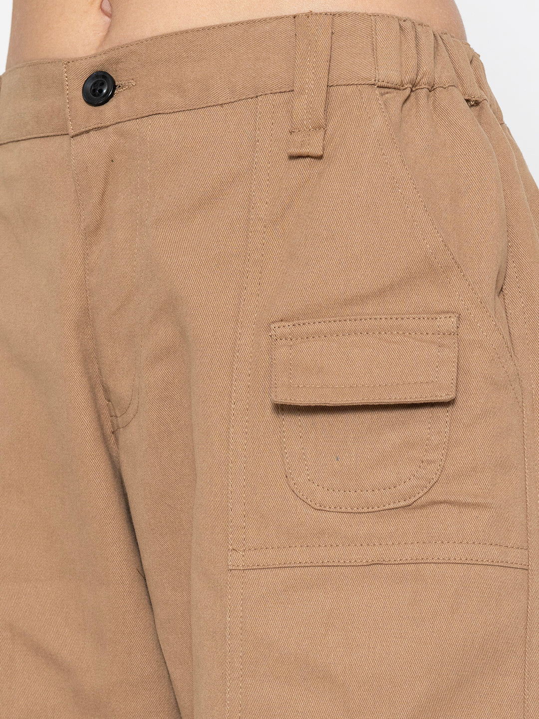 Lifestyle shot of beige cotton baggy trousers styled with tee
