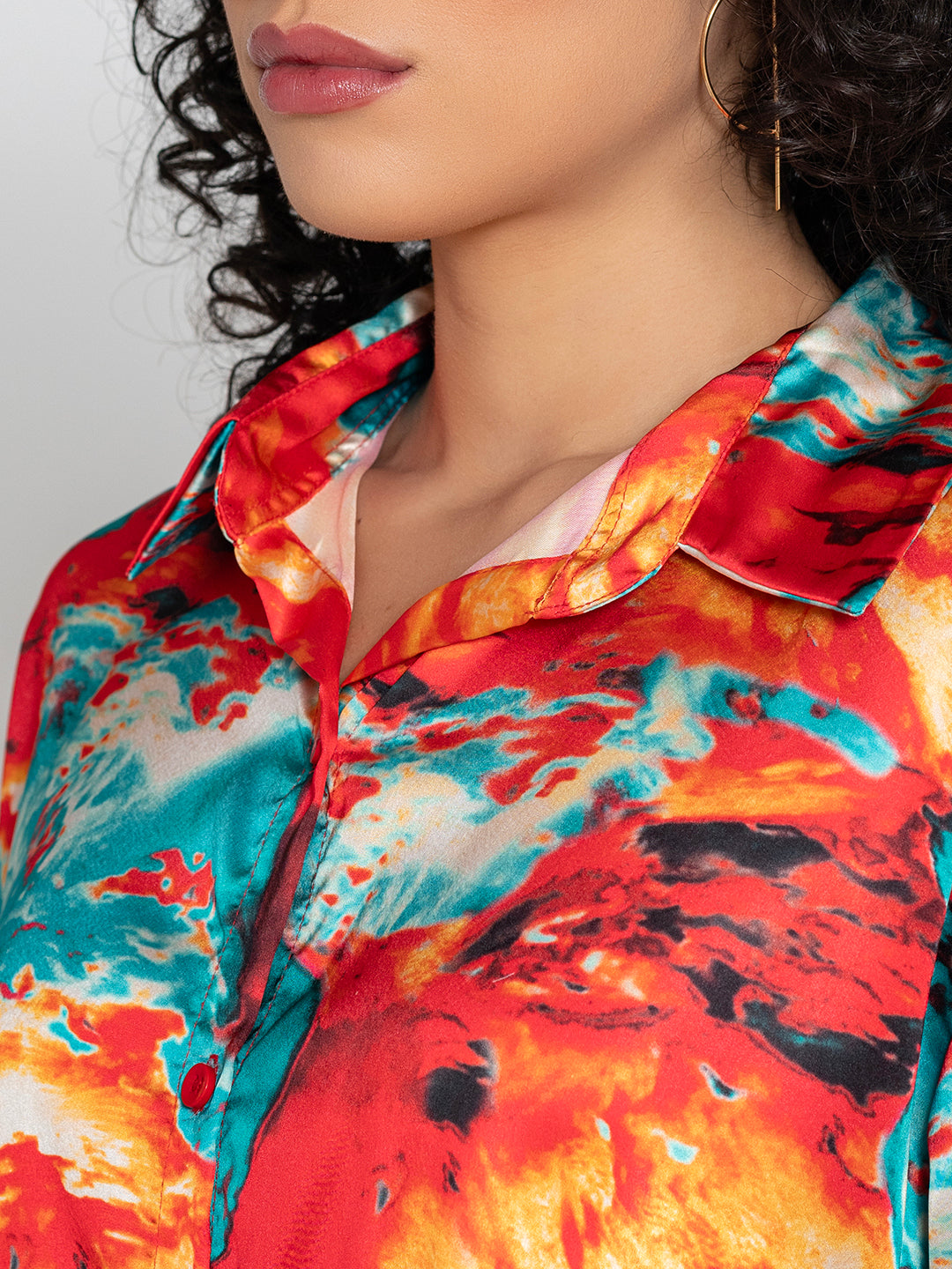 Lifestyle shot of red floral satin shirt styled with denim