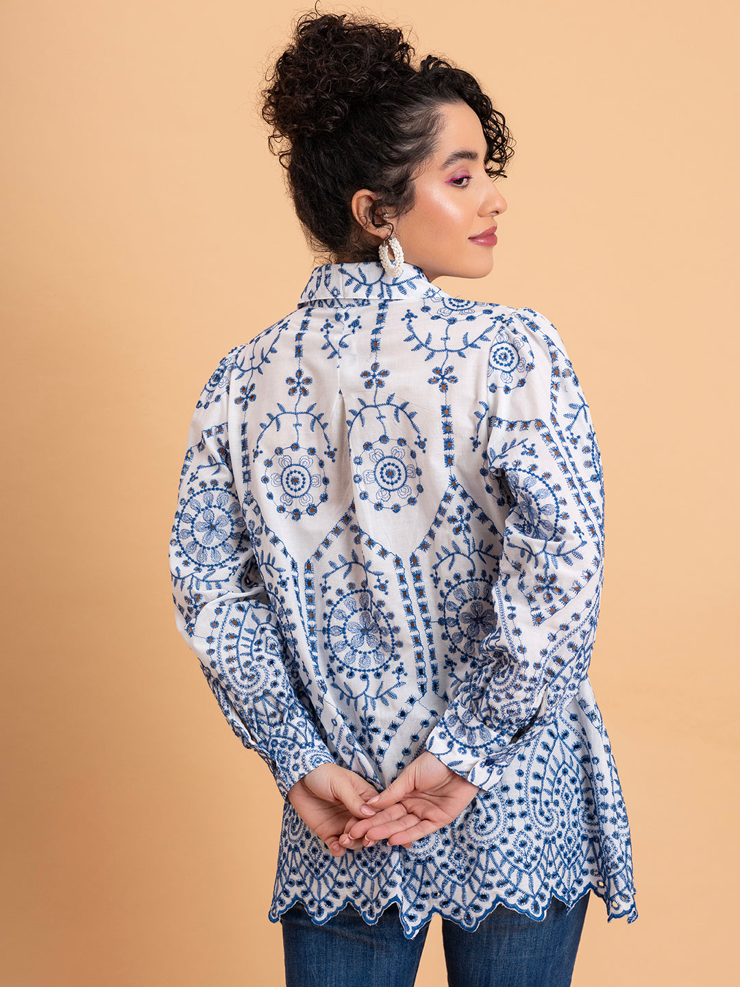 Close-up of intricate blue schiffli embroidery on white cotton shirt