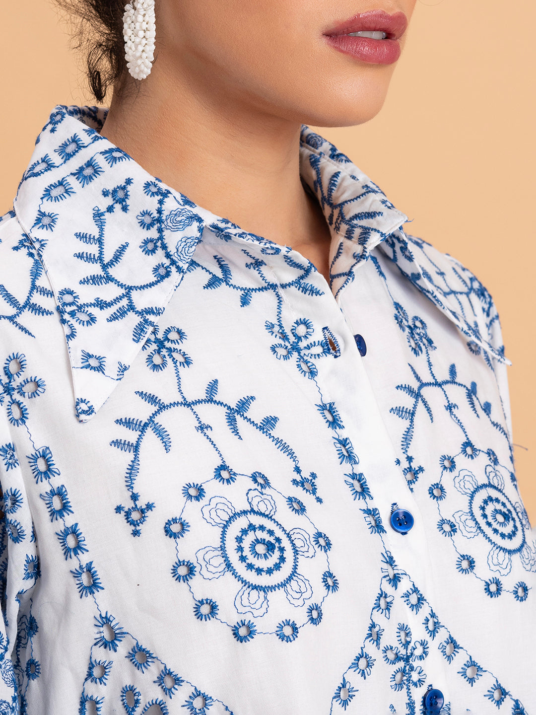 Detail of classic shirt collar and button placket on white embroidered shirt